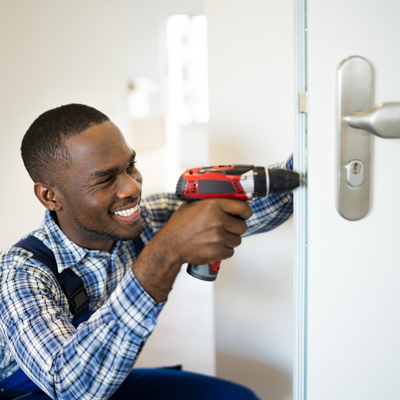 Locksmith in Balham and South London young smiling male adult fixing interior door lock in new build home